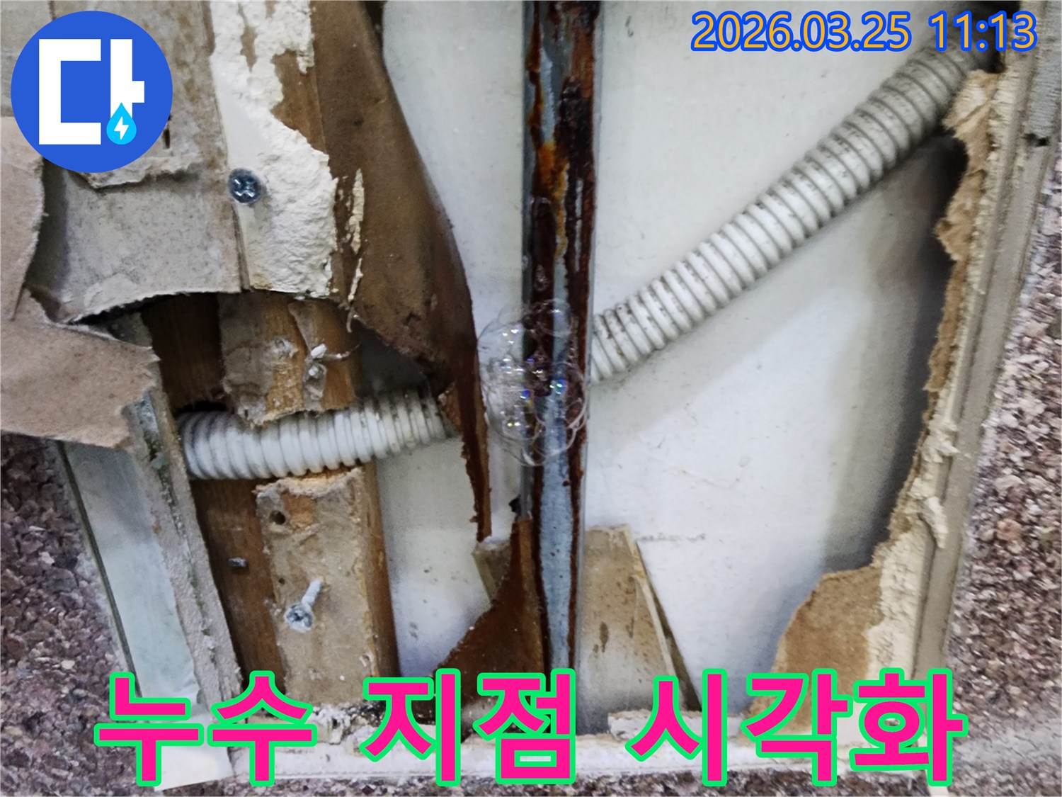 배관에서 새어 나오는 물과 공기가-비눗물과 만나-거품으로 변하여-누수 지점을 시각적으로 보여주는 장면입니다