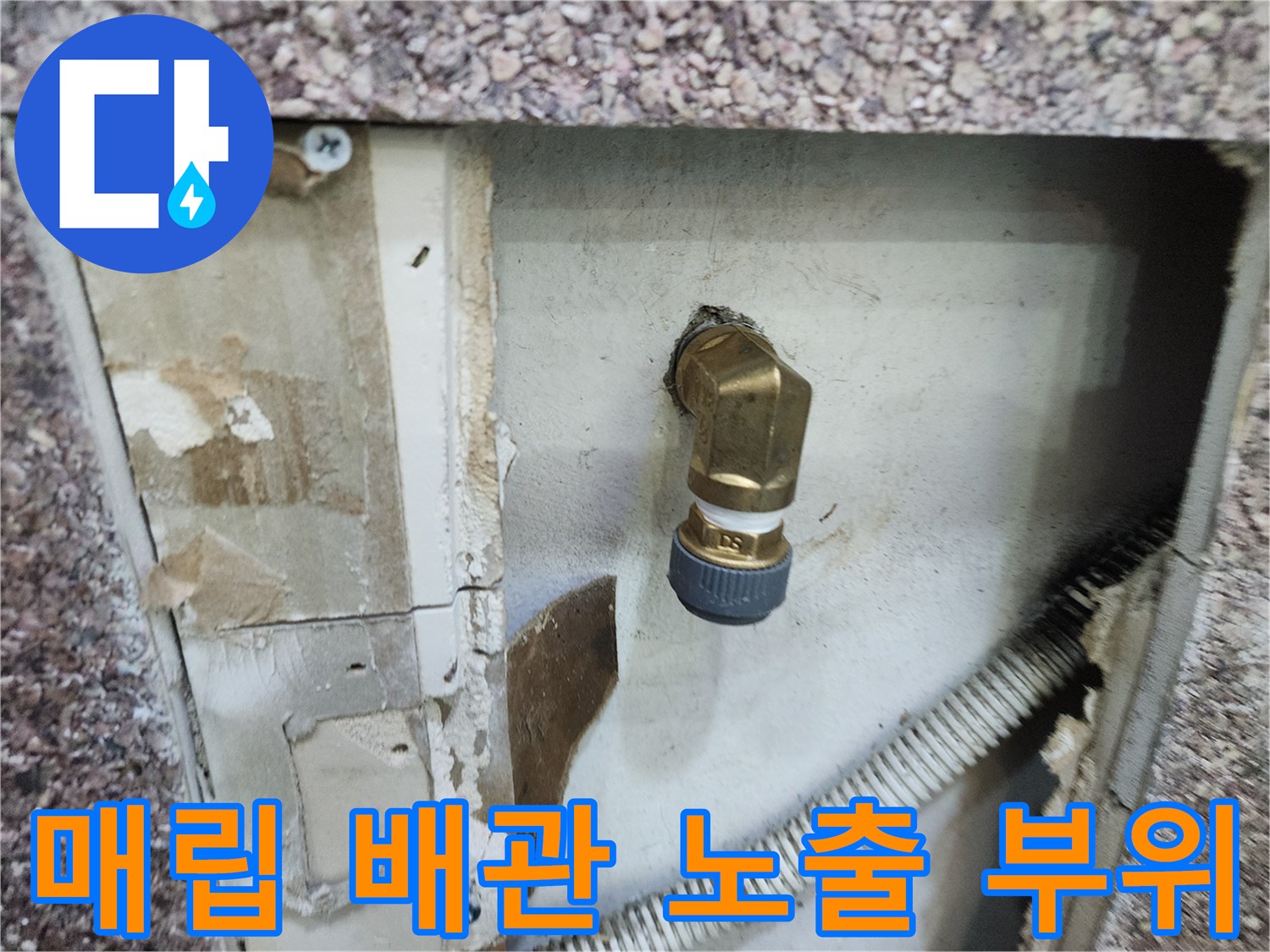 벽 내부의 황동색 수도 부품과 흰색 주름 배관