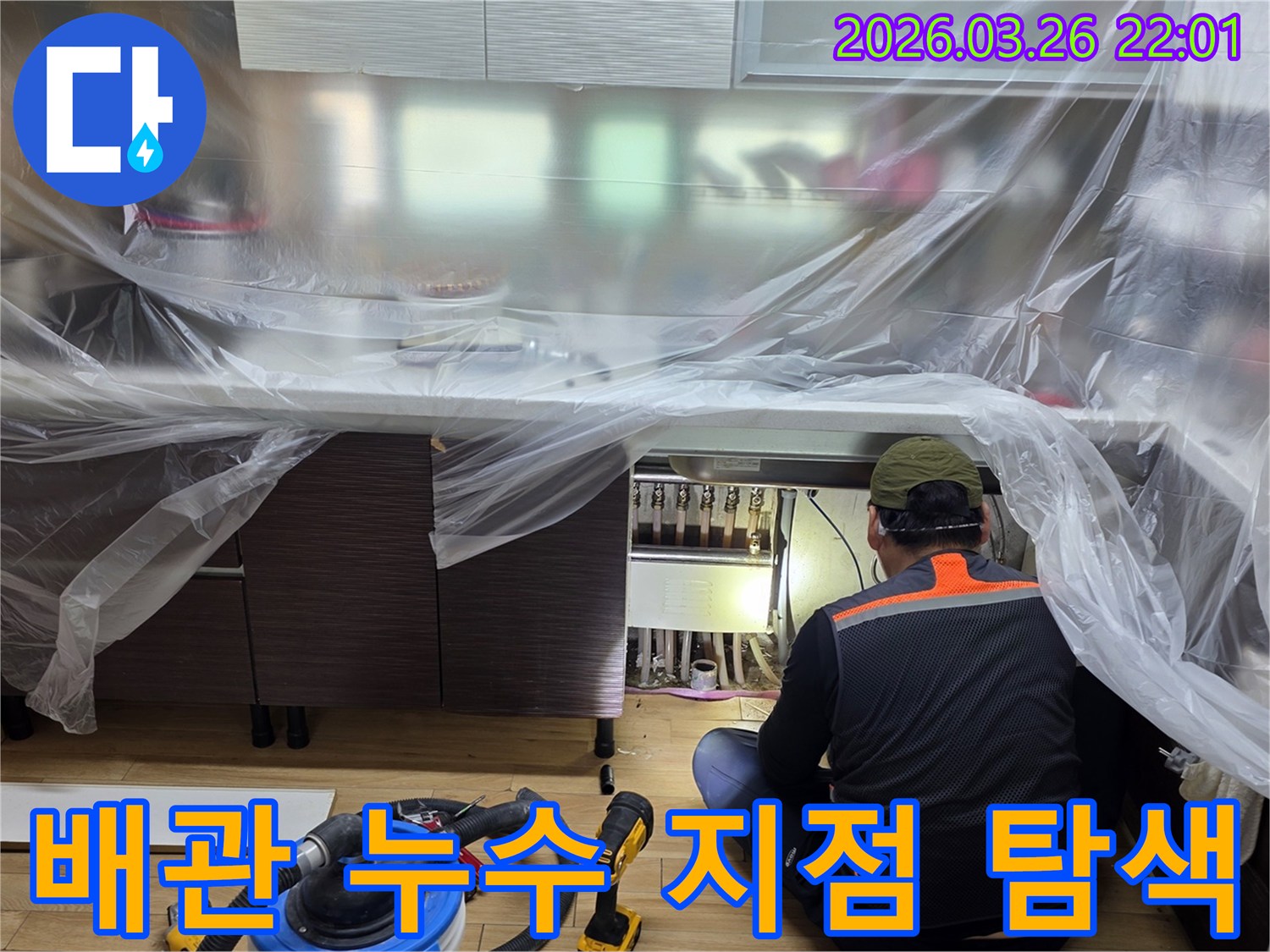 누수 엔지니어가-주방 하부장 아래-보일러 분배기 주변의-배관 연결부를-집중적으로-검사하고 있습니다.