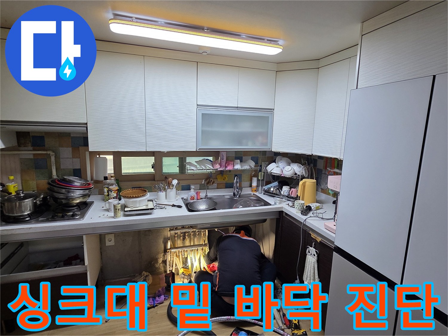 싱크대 하부 공간에서 진행되는 누수 지점 탐색 및 확인 작업