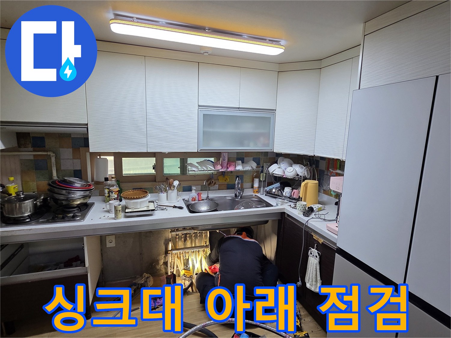 작업자가-싱크대-하부-배관-상태를-살피는-모습
