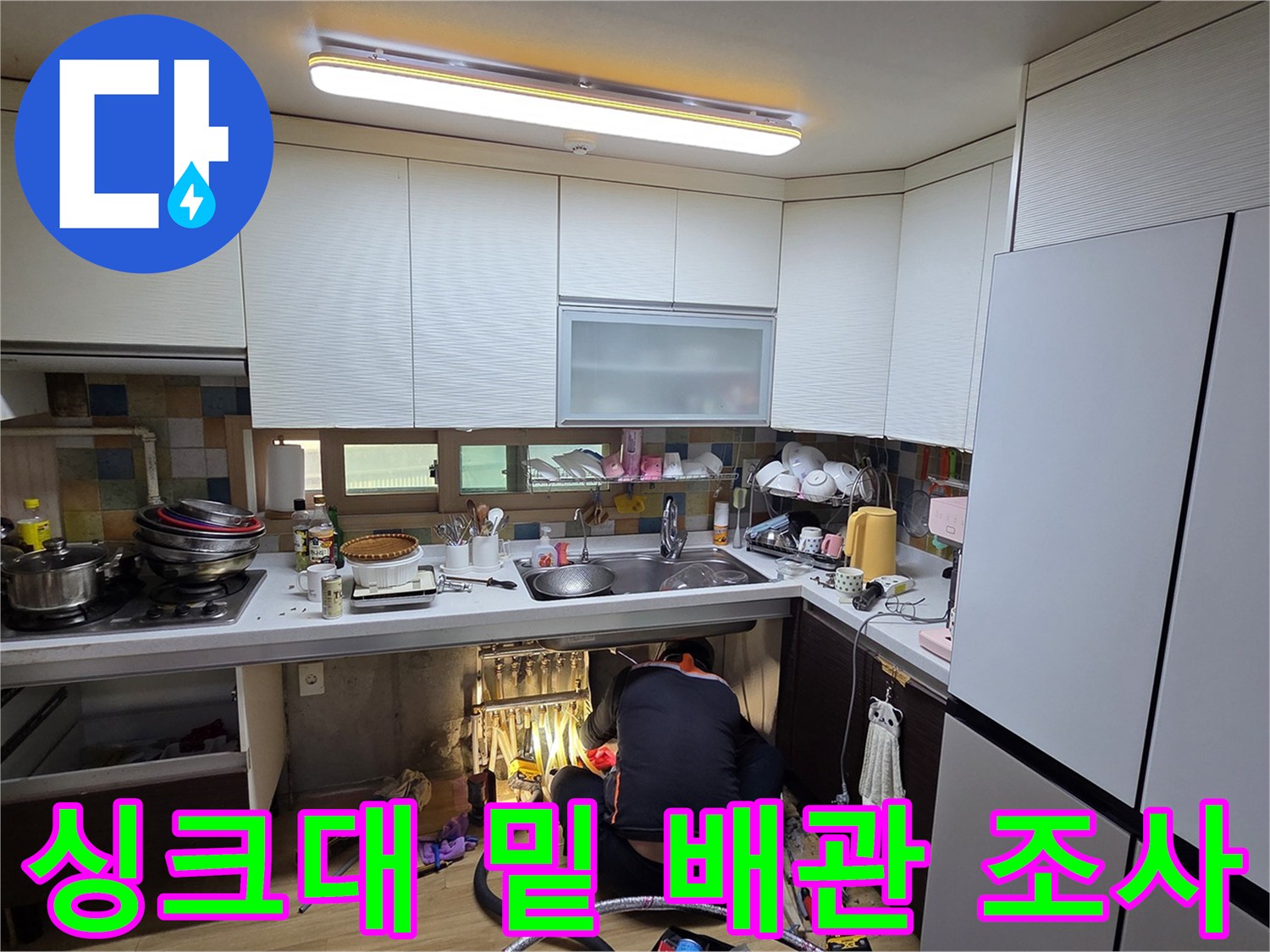좁은-싱크대-하부-공간에서-배관을-조사하는-전문가