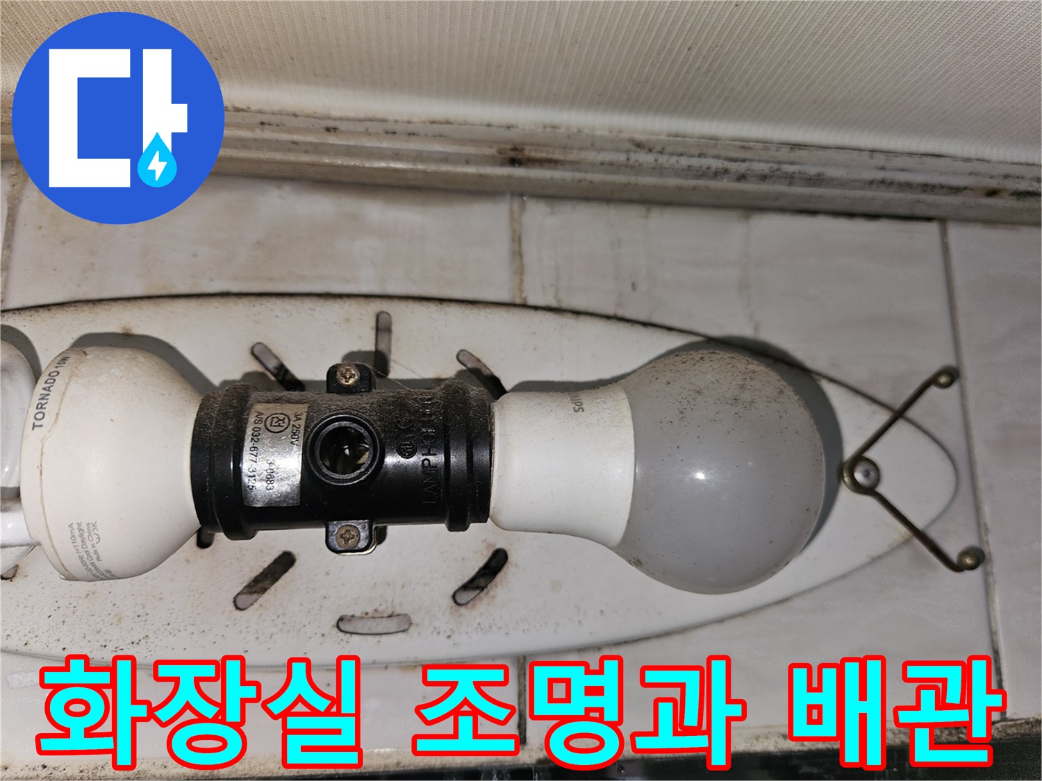 욕실 천장 조명기구와 그 주변에 노출된 배관 부위를 촬영하였습니다.