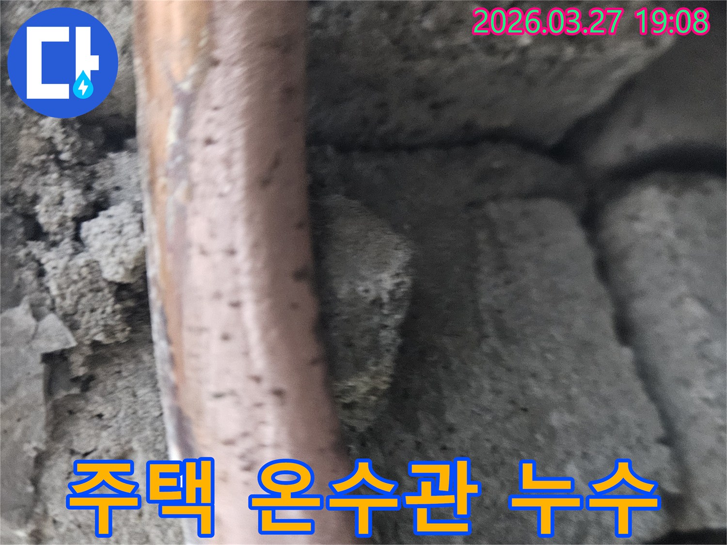 콘크리트-구조물-사이에-놓인-오래된-주택-온수-배관의-부식-및-누수-현상을-보여주는-사진입니다