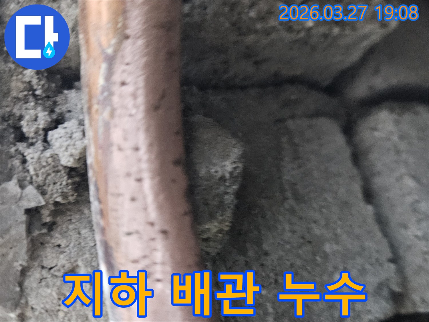 콘크리트-구조물-사이에-놓인-오래된-지하-배관의-부식-및-누수-현상을-보여주는-사진입니다