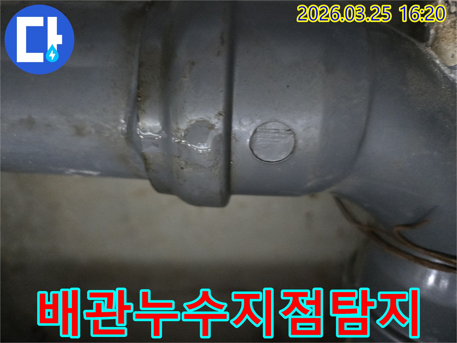 회색 배관의 연결부에서-물이 맺혀 떨어지는-누수 현장의-클로즈업 이미지입니다.