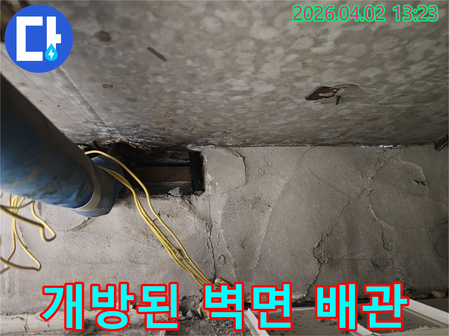 콘크리트 벽을-개방하여-파란색 배관과-노란색 전선이-드러난-누수-탐지-현장입니다.