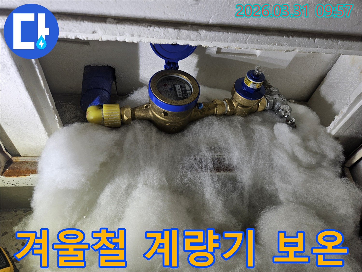 겨울철 한파로부터 수도 계량기를 보호하기 위한 보온재의 설치 상태를 점검하는 사진입니다