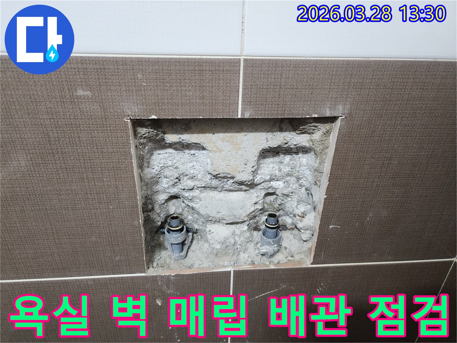중랑구 신내동 빌라 욕실의 벽체 매립 배관을 점검하기 위해-벽면 타일을 제거하고 내부 배관을 확인하는-공사 현장의 초기 단계입니다.