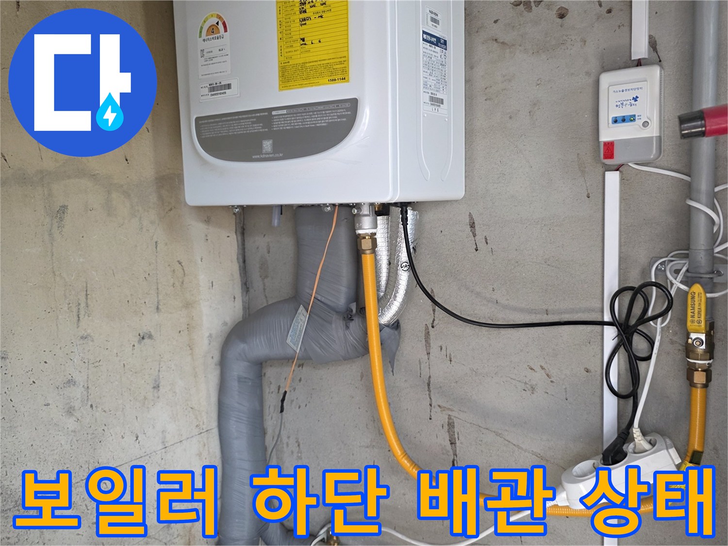 보일러실 벽면-노란색 배관과 전기 콘센트의 모습