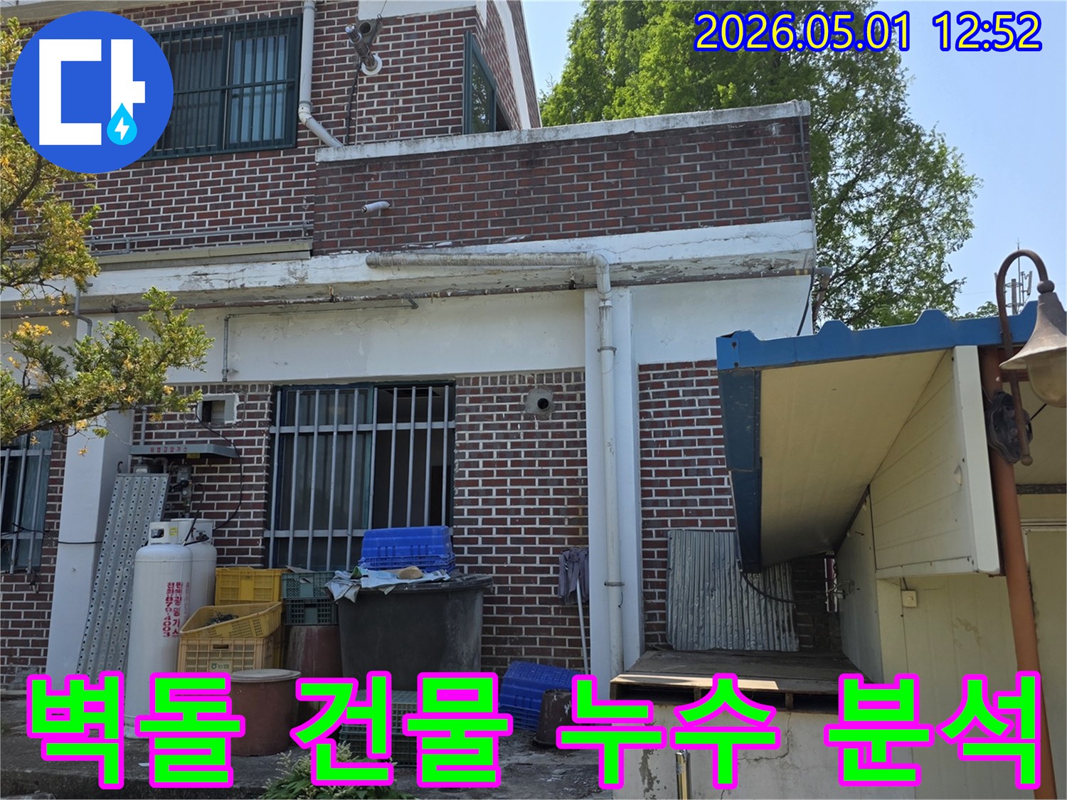 양주 백석읍 오산리 오래된 벽돌 건물 외벽에서-누수 엔지니어가 누수 흔적을 통해-건물의 취약점을 분석하는 모습