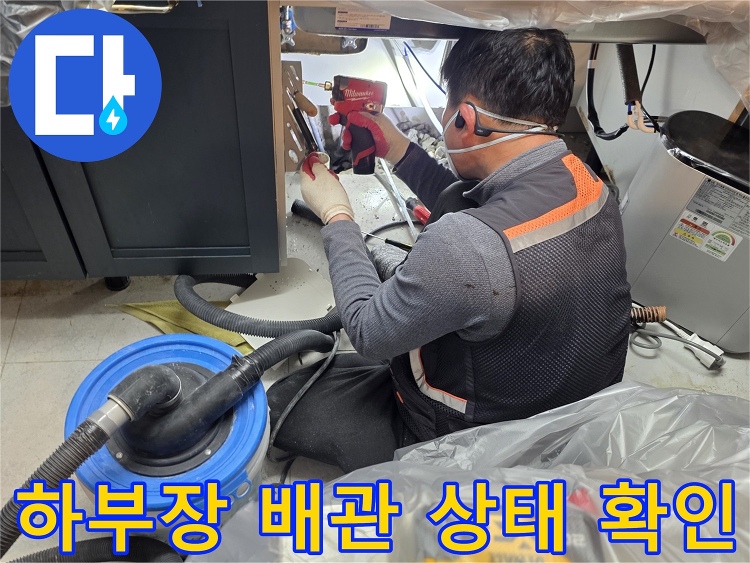 싱크대 밑 공간에서 배관 연결부를 손으로 점검하는 엔지니어