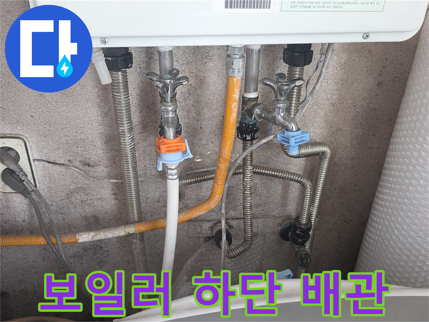 보일러 아래쪽의 노란색 호스와 은색 금속 배관 연결 상태