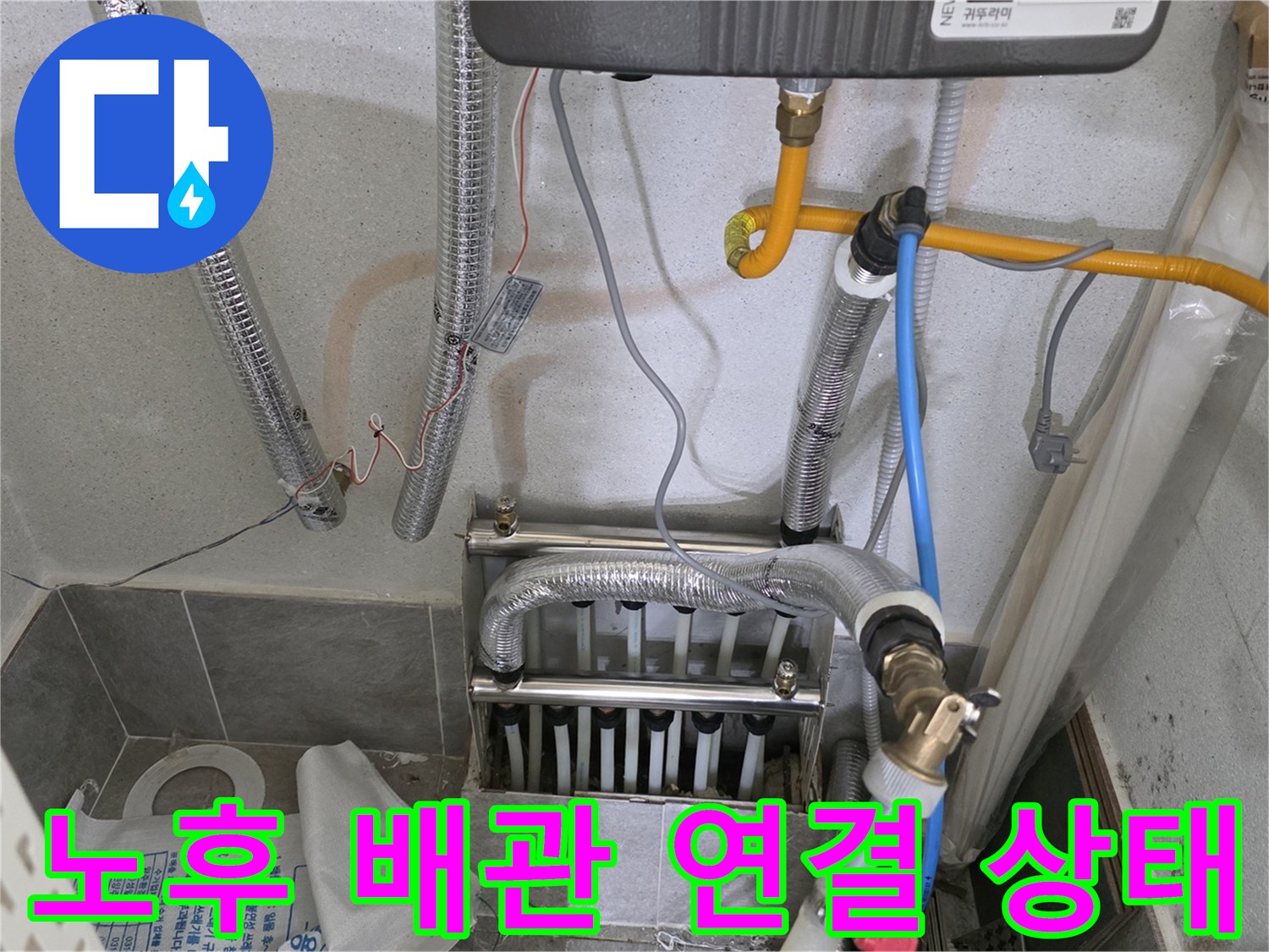 보일러 하단 은색 보온재 배관과 노란색 온수관 연결 부위