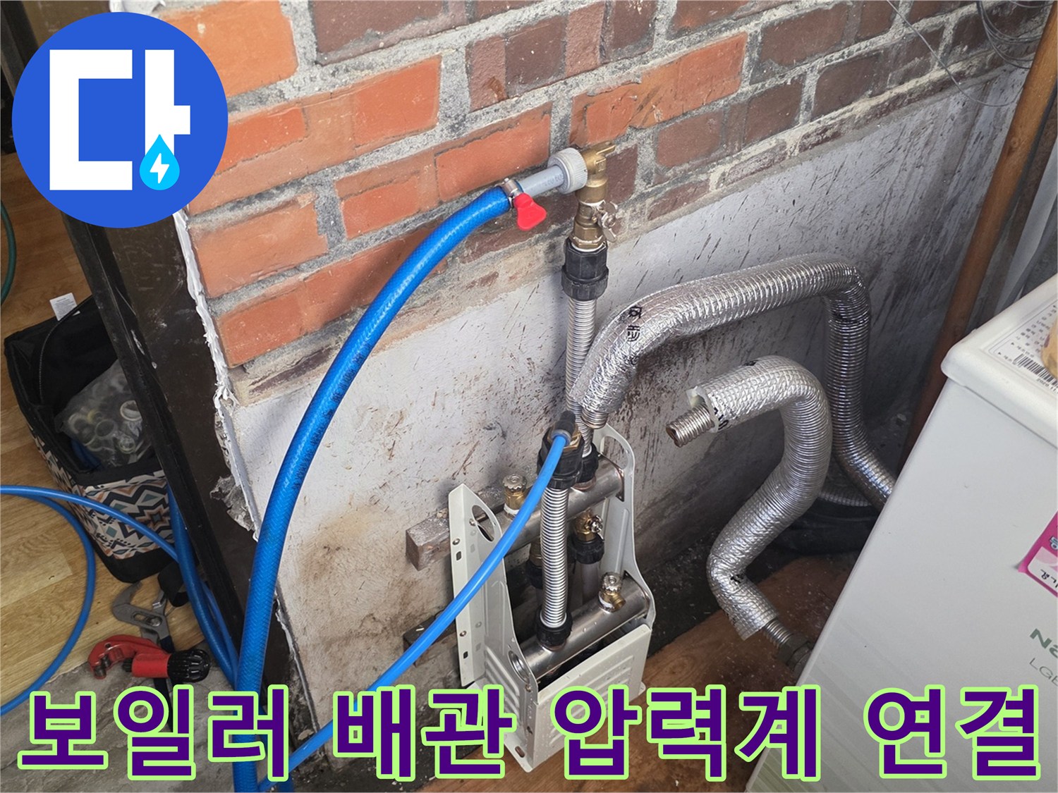 파란색 에어 호스가 보일러 배관 부속에 연결된 사진입니다.