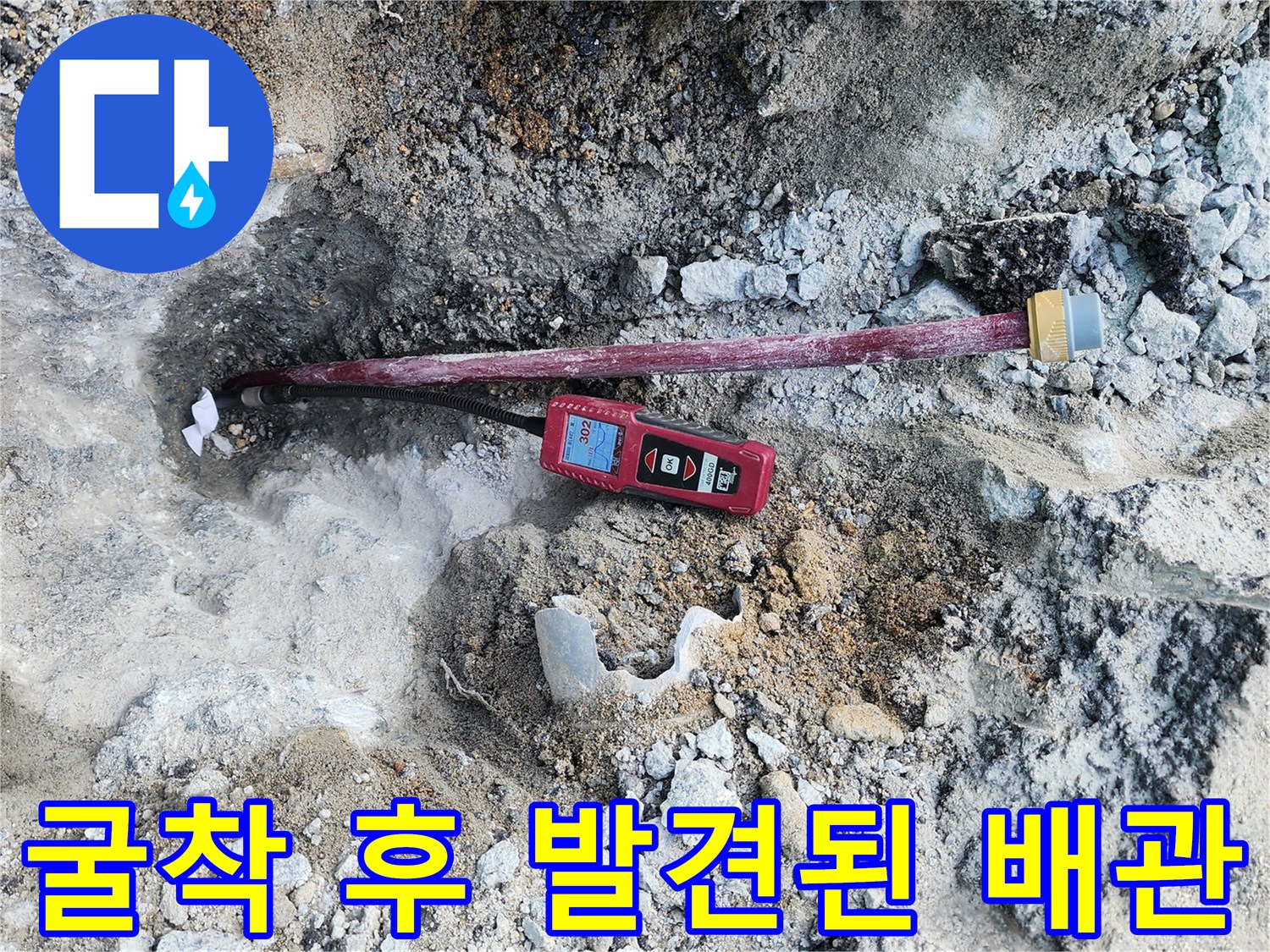 흙을 파내어 드러난 붉은색 배층과 수치 확인용 측정 장비