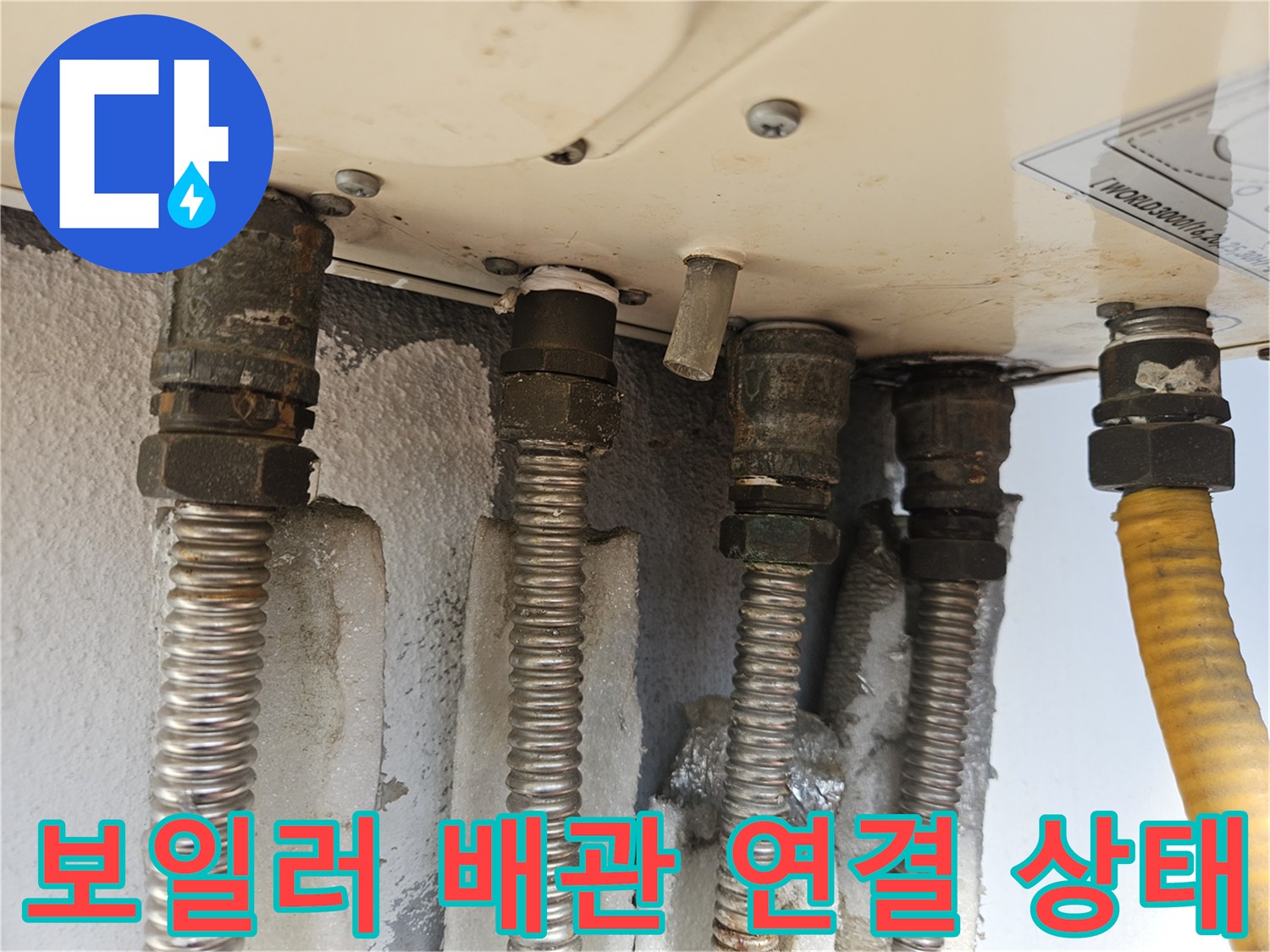 보일러 하단부-금속 배관과 유연한 호스의 연결 부위 모습
