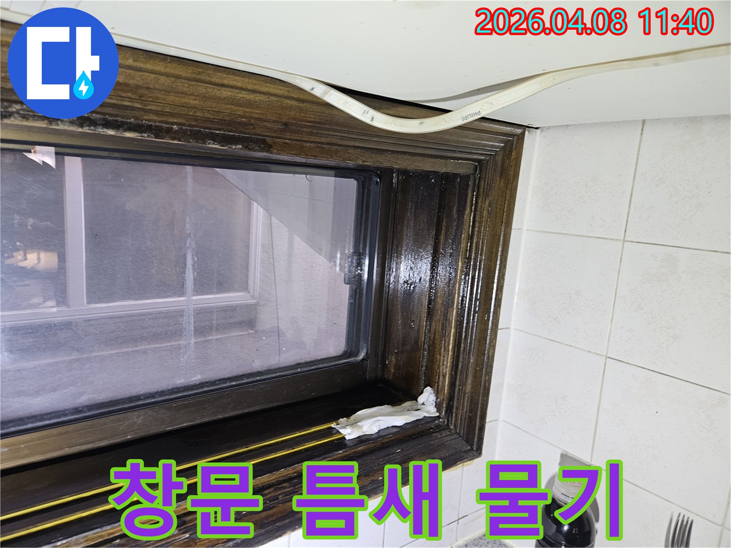 오래된 창틀에서 발견된 물샘-흔적을 보여주는 이미지로-누수 전문가가 현장을 점검하고 있습니다.