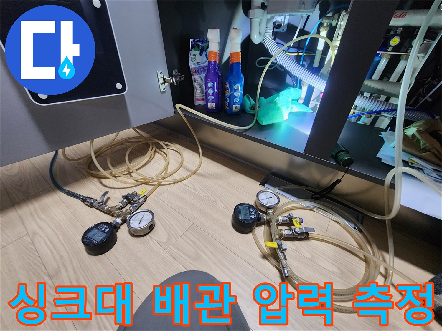 싱크대 아래 배관에 연결된 압력계와 가스 탐지용 호스들