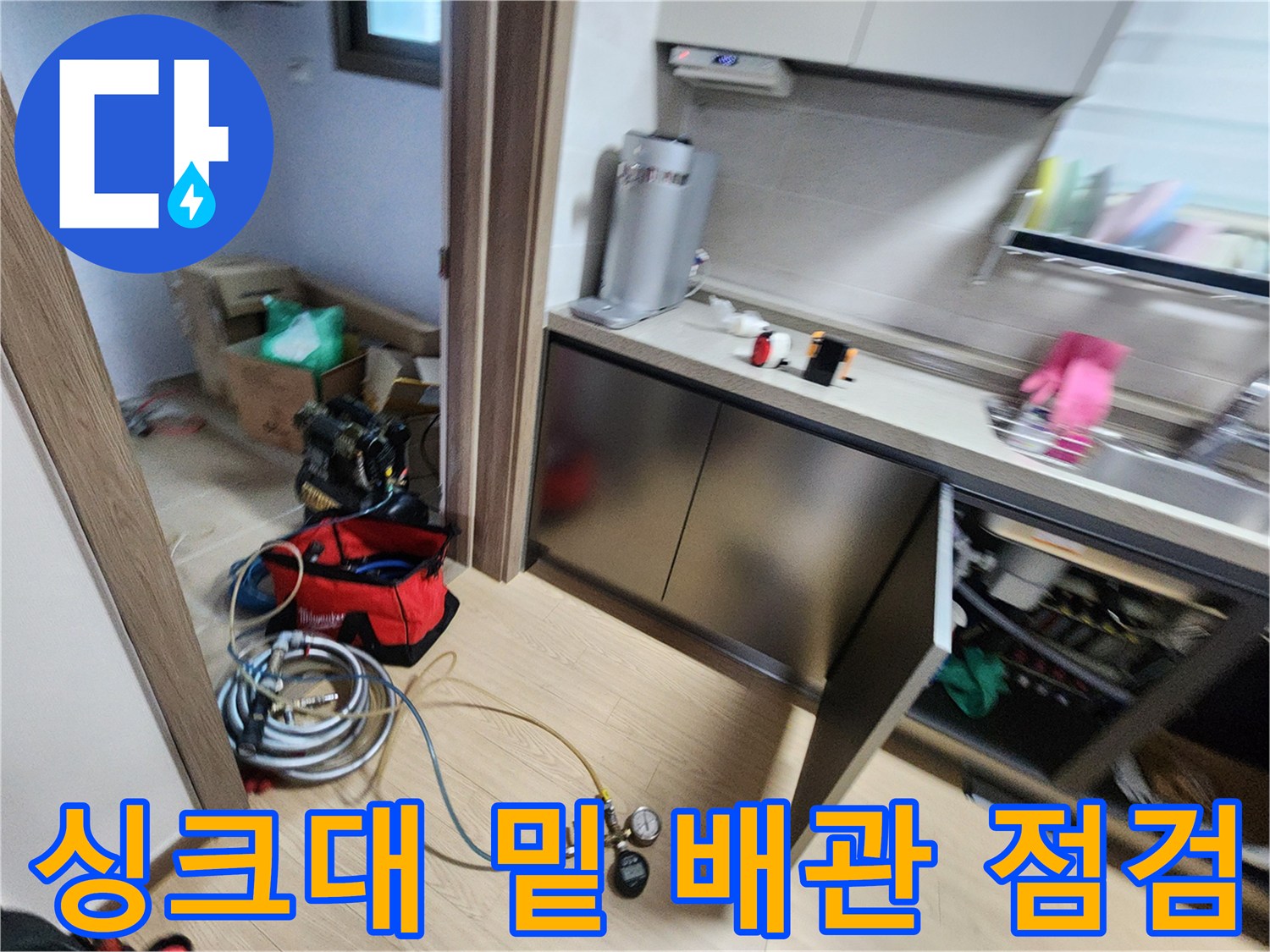 싱크대 하부 공간에 설치된 누수 탐지용 압력 측정 장치와 호스들
