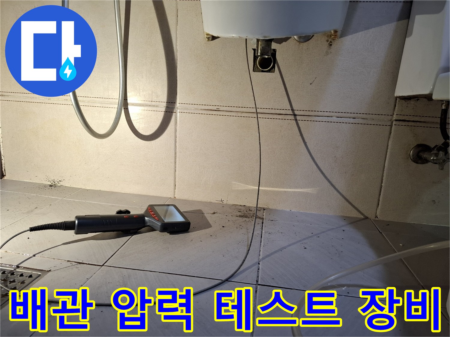 온수 배관 점검을 위해 바닥에 놓인 가스 탐지 장비와 보일러 하단 배관 모습