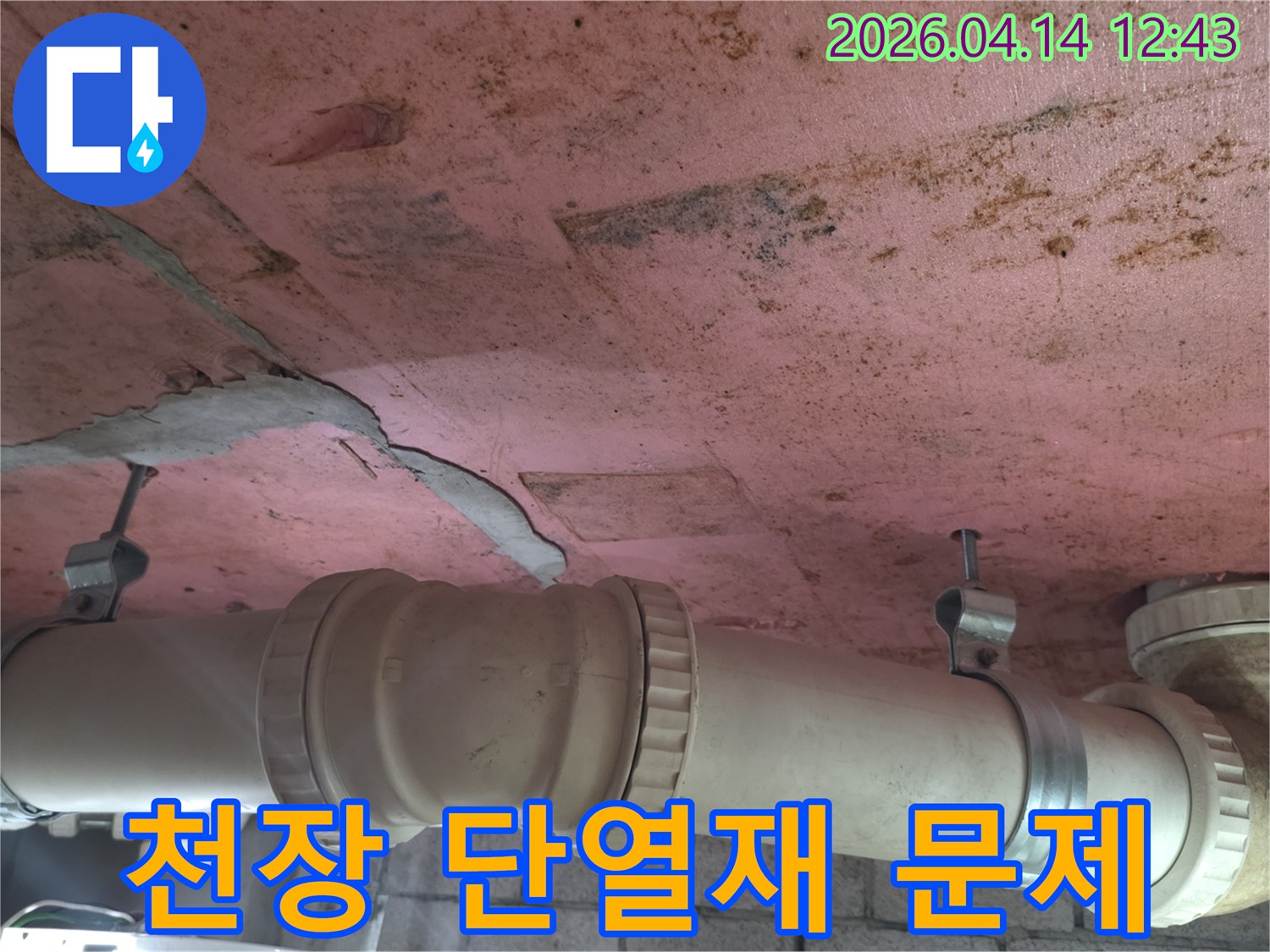 천장 마감재의 손상된 부분과-그 아래에 위치한 수도 배관의-연결 부위를 상세히 보여주는-누수 현장 사진입니다.