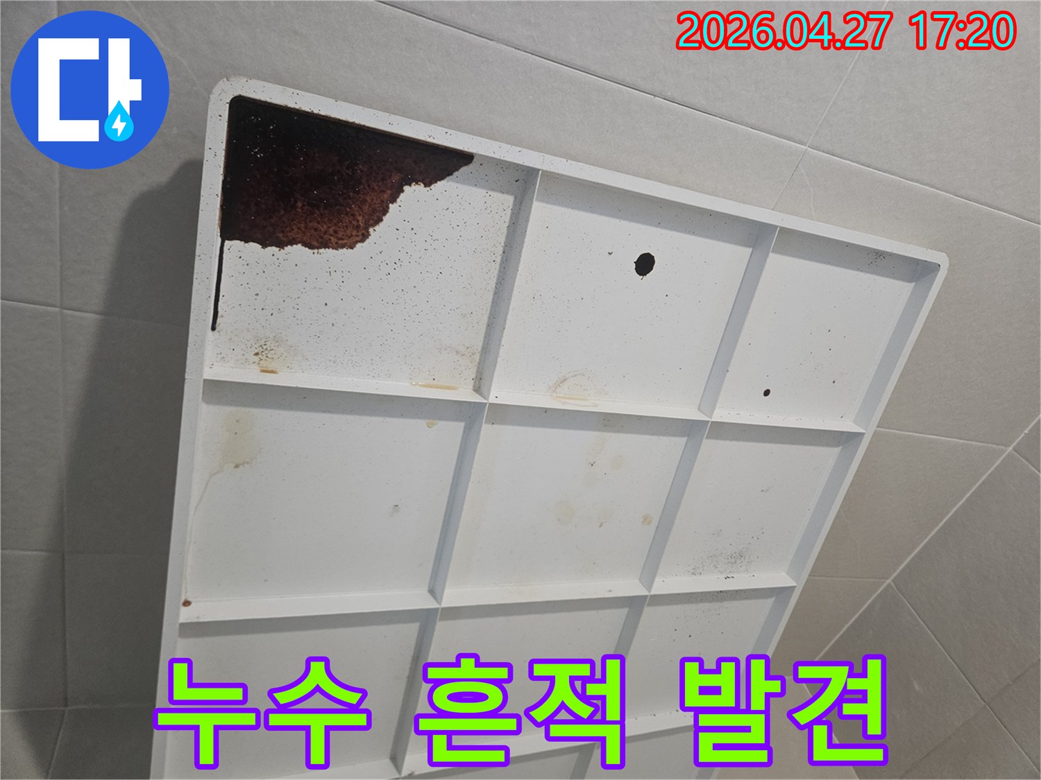 오랜 기간 누수가 진행되어-배수판에 짙은 갈색 물이 고여있는-현장 사진입니다.