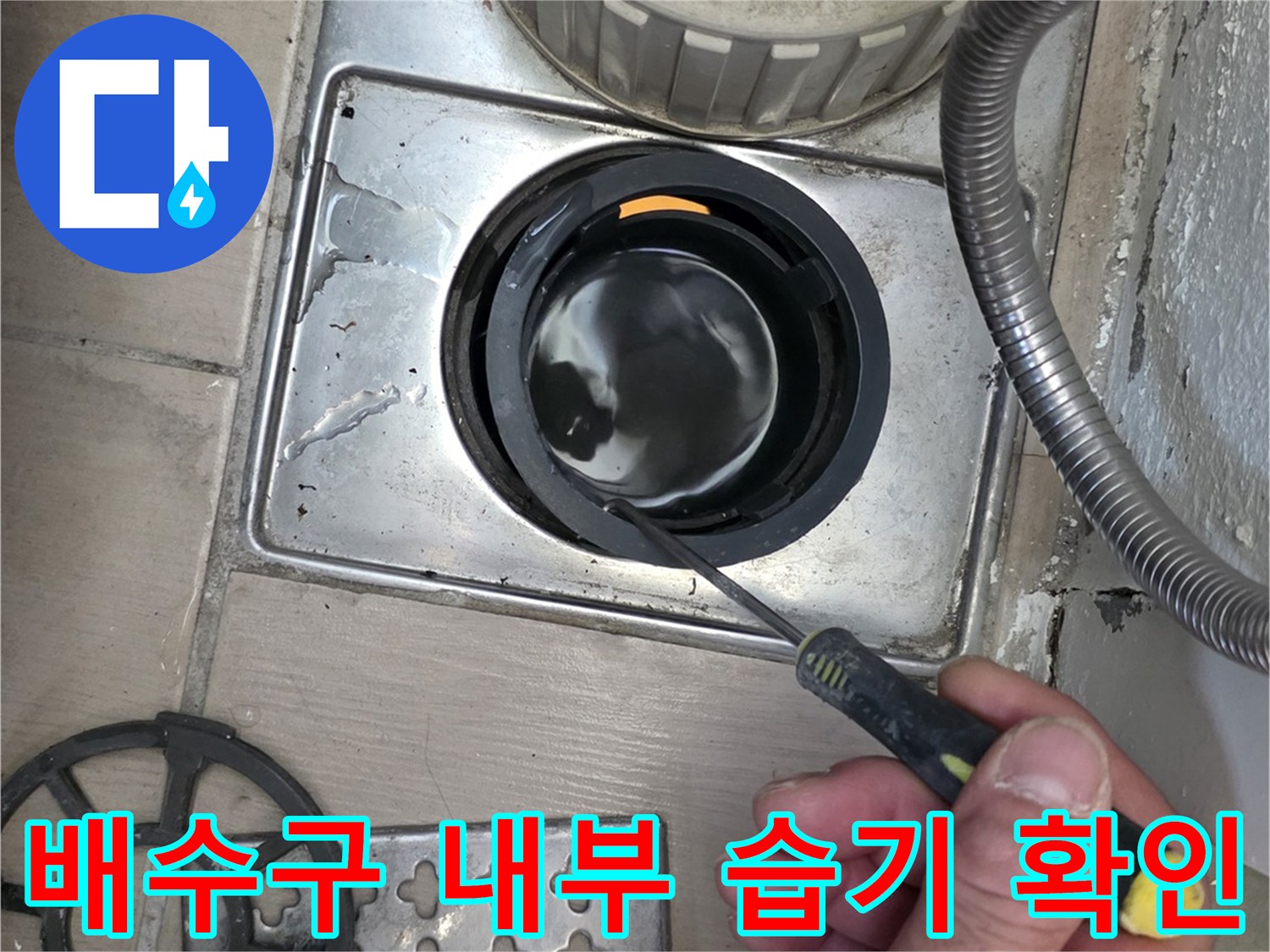 도구를 사용하여 배수구 유가 안쪽을 살피는 손의 움직임