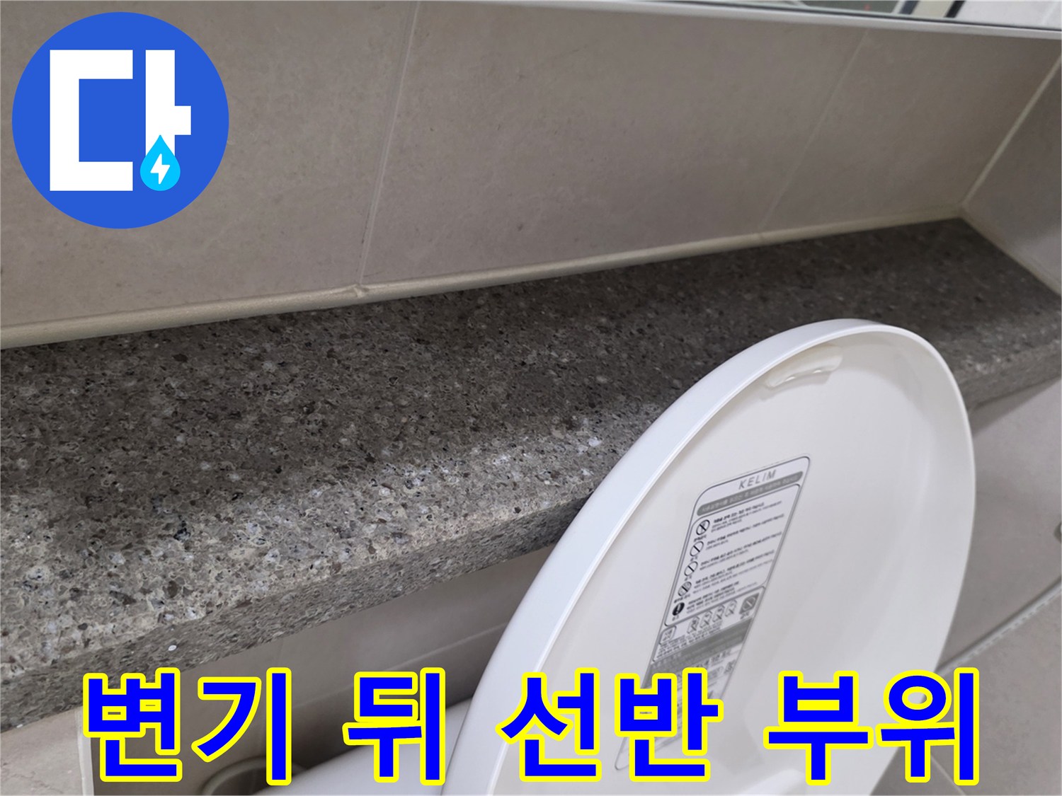 욕실 변기 뒤쪽의 대리석 선반과 벽면 타일 경계