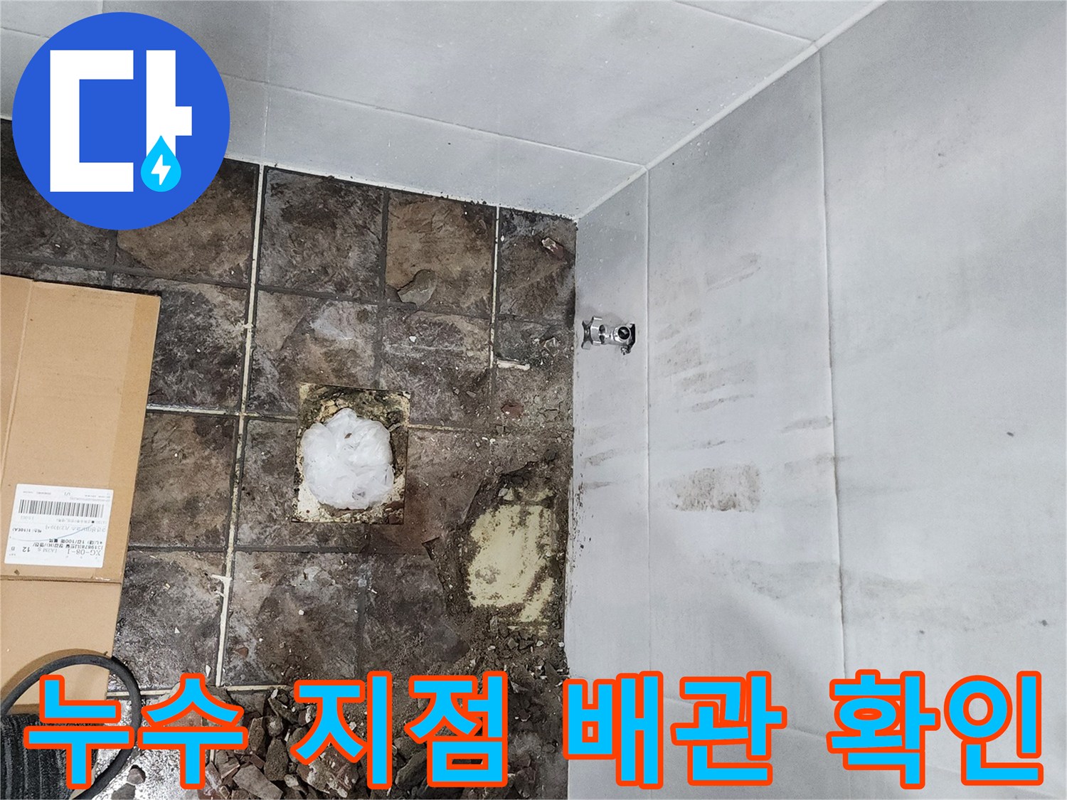 젖은 바닥 흙과 함께 드러난 손상된 수도 배관 연결 부위