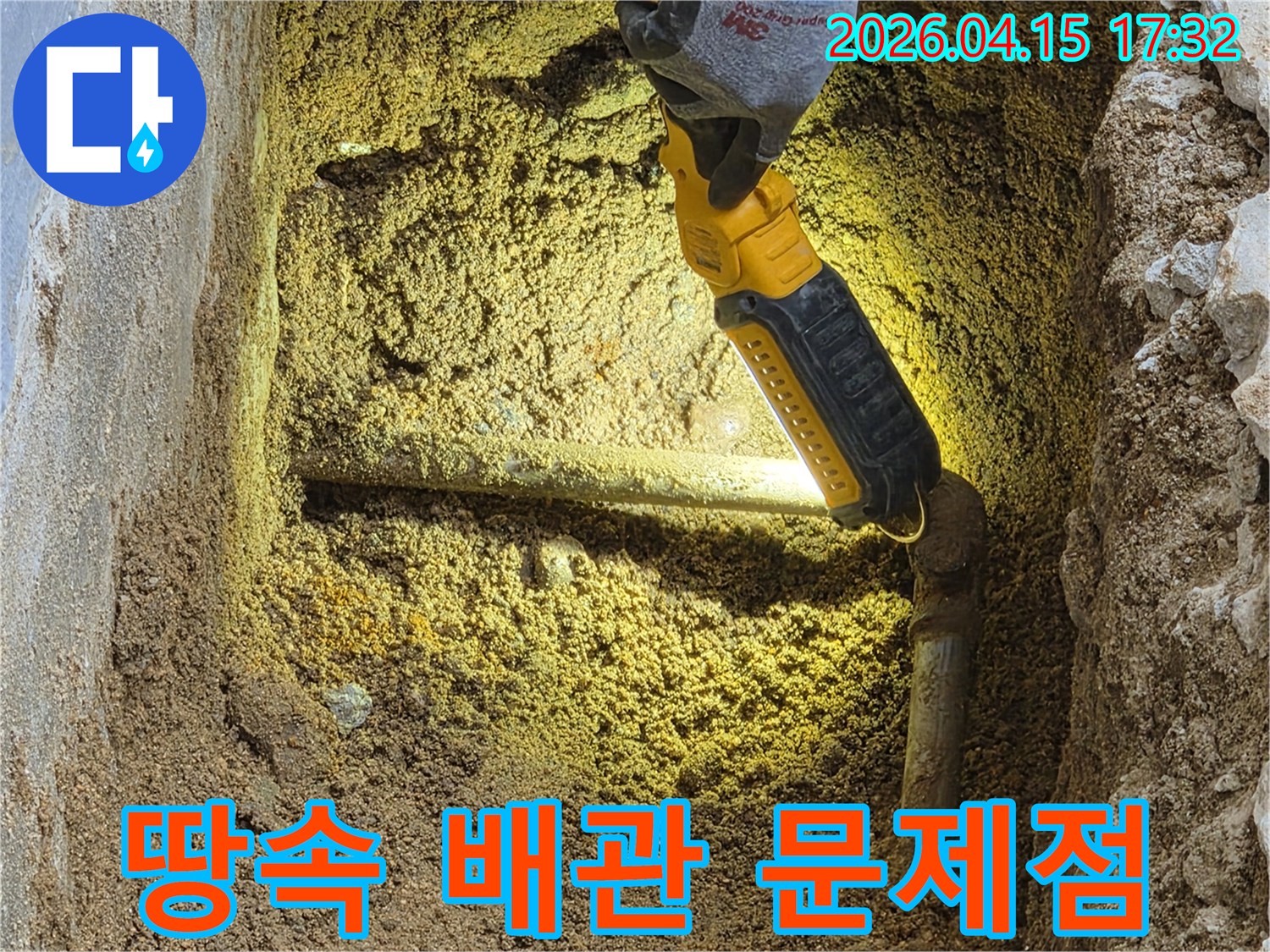 전문가가-손전등으로-땅속에-묻힌-배관의-문제점을-정확히-파악하며-누수-원인을-분석하고-있습니다.