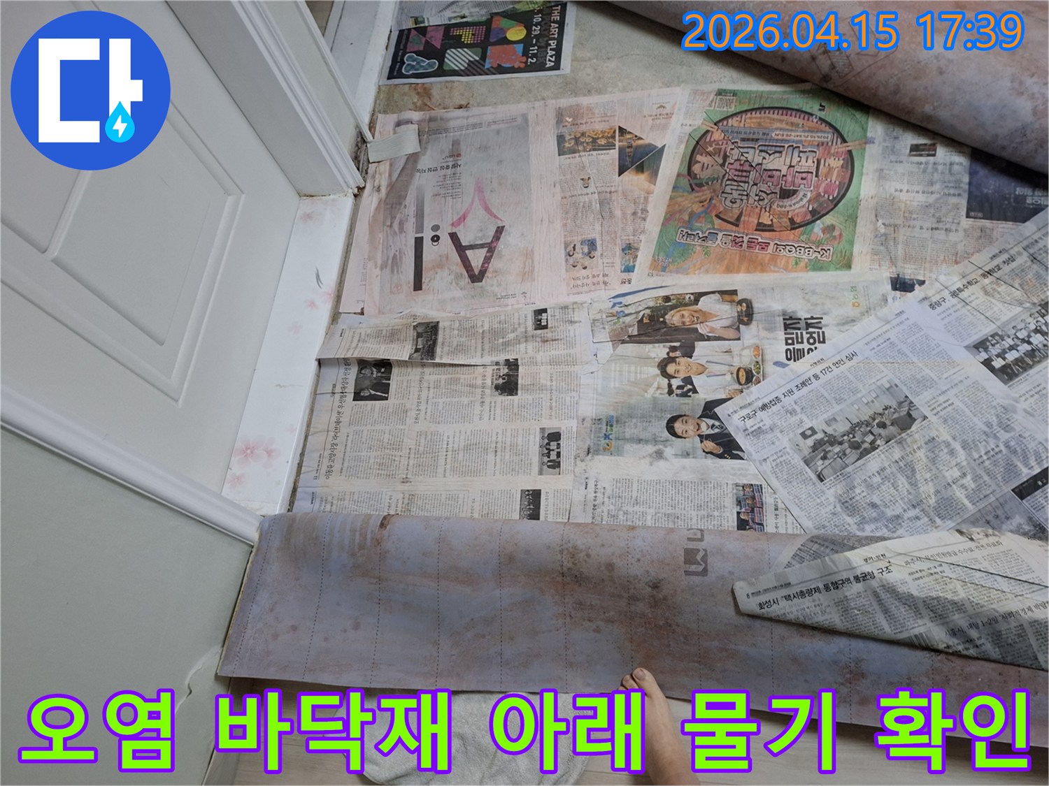 누수로 인해 얼룩진 바닥재를 신문지로 덮어-안전을 확보하고-누수 진단을 위한 현장 준비가 완료된 모습입니다
