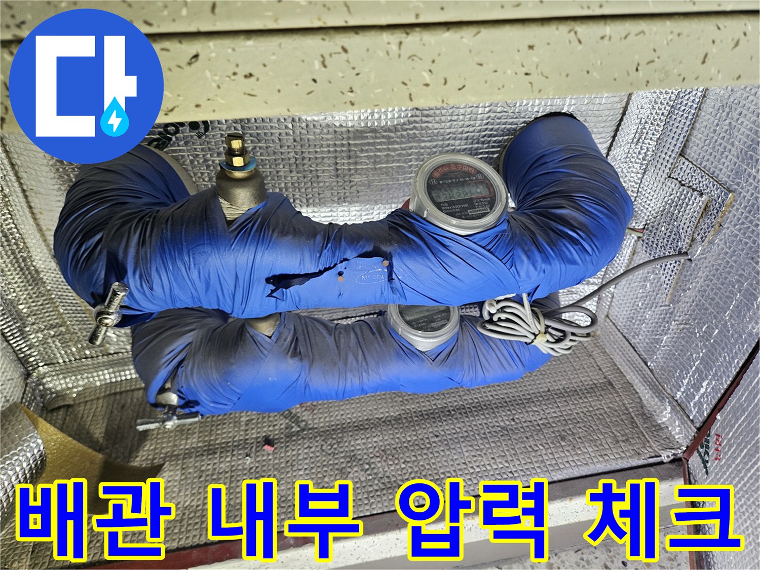 파란색 보온재로 감싸진 배관의 압력계 측정 장면