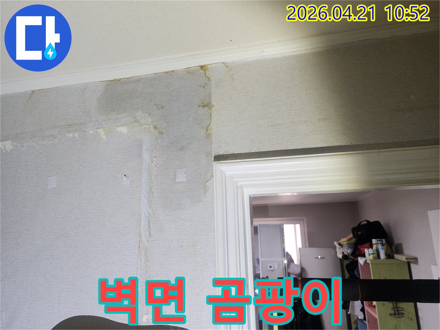 벽면 가장자리를 따라 물이 스며들어 벽지가 변색되고 손상된-누수 현장을 정밀하게 촬영한 이미지입니다.