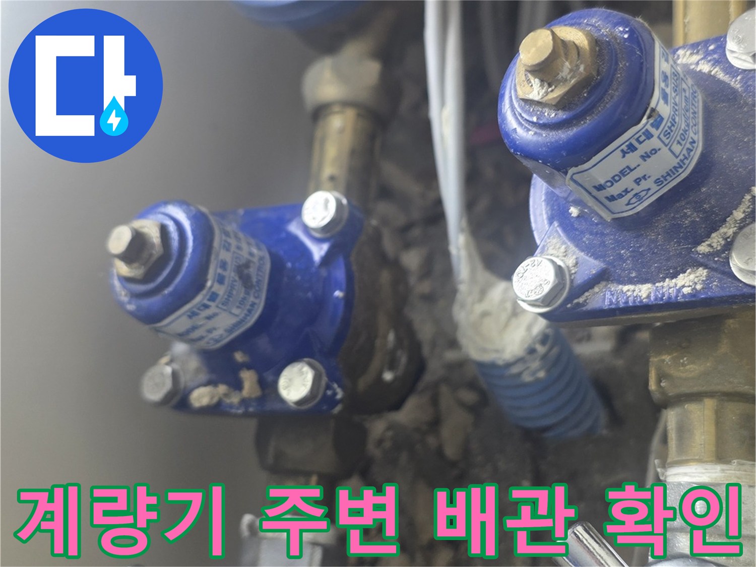 파란색 밸브와 은색 금속 배관이 연결된 계량기 내부 모습입니다.