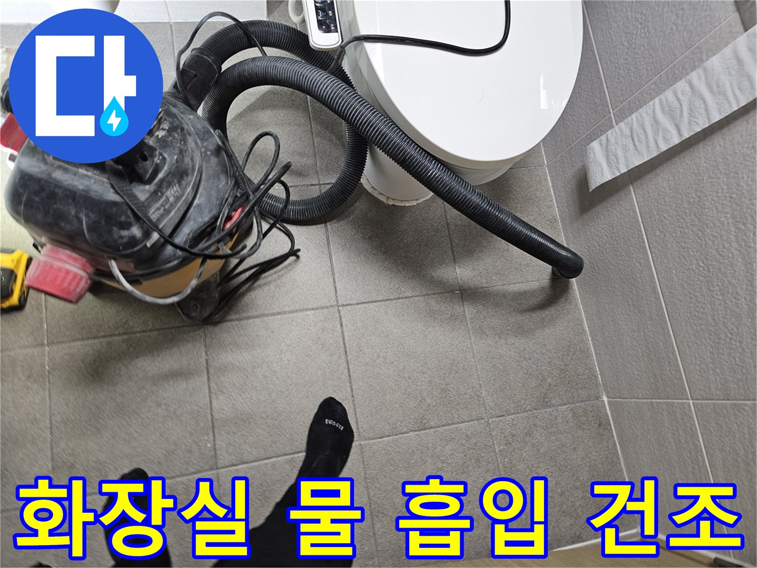 오산시 고객 댁 화장실에서-누수 엔지니어가-변기 주변의 물을-습식 청소기로 흡입하고-바닥을 건조하는 모습