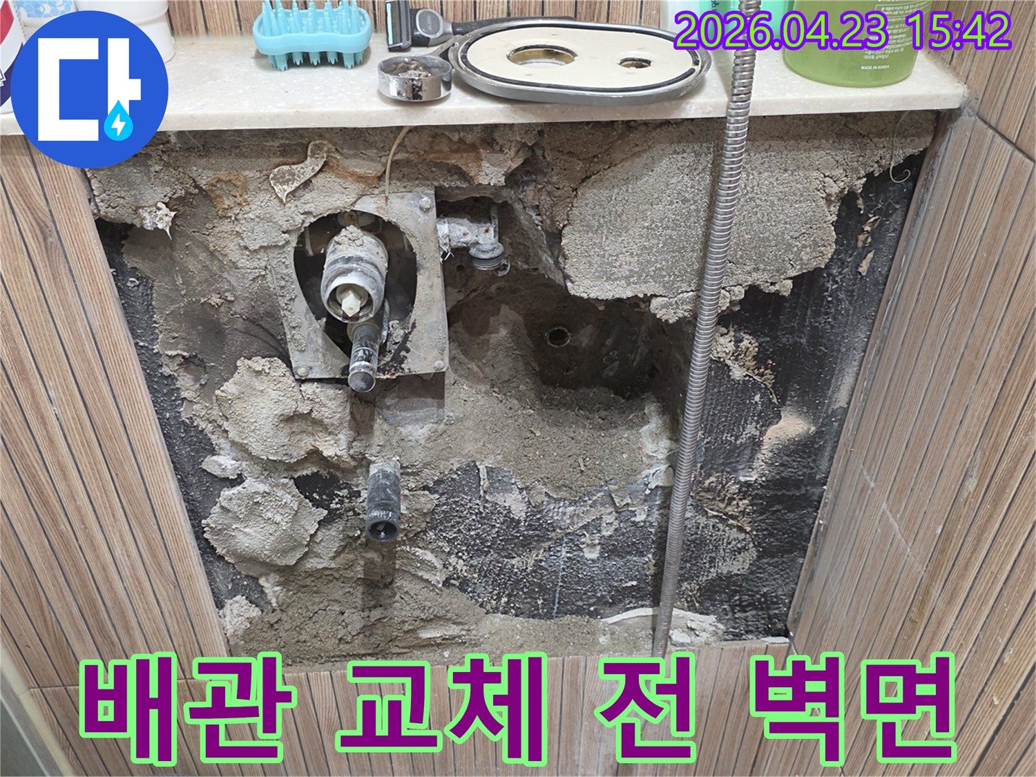 서울 노원구 상계동의 욕실 누수 현장에서-배관 교체 작업을 시작하기 전-벽면의 타일을 제거하고-내부 상태를 보여주는 사진입니다.