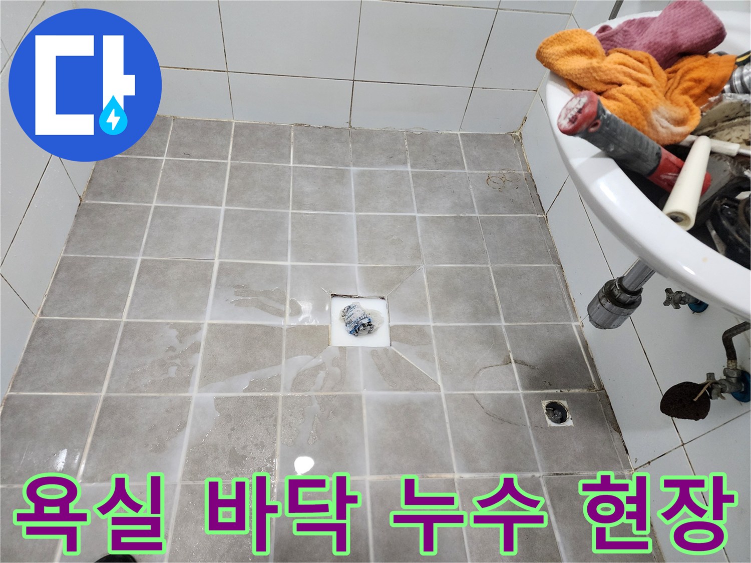 욕실 바닥 타일 위에-물이 고여-누수 문제가-발생했음을 보여주는-현장 사진입니다