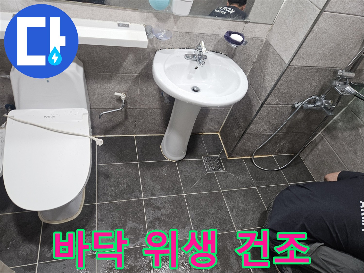 누수 수리 작업 후-고객님의 위생을 위해-욕실 바닥을 깨끗하게 청소하고 건조하는 모습입니다
