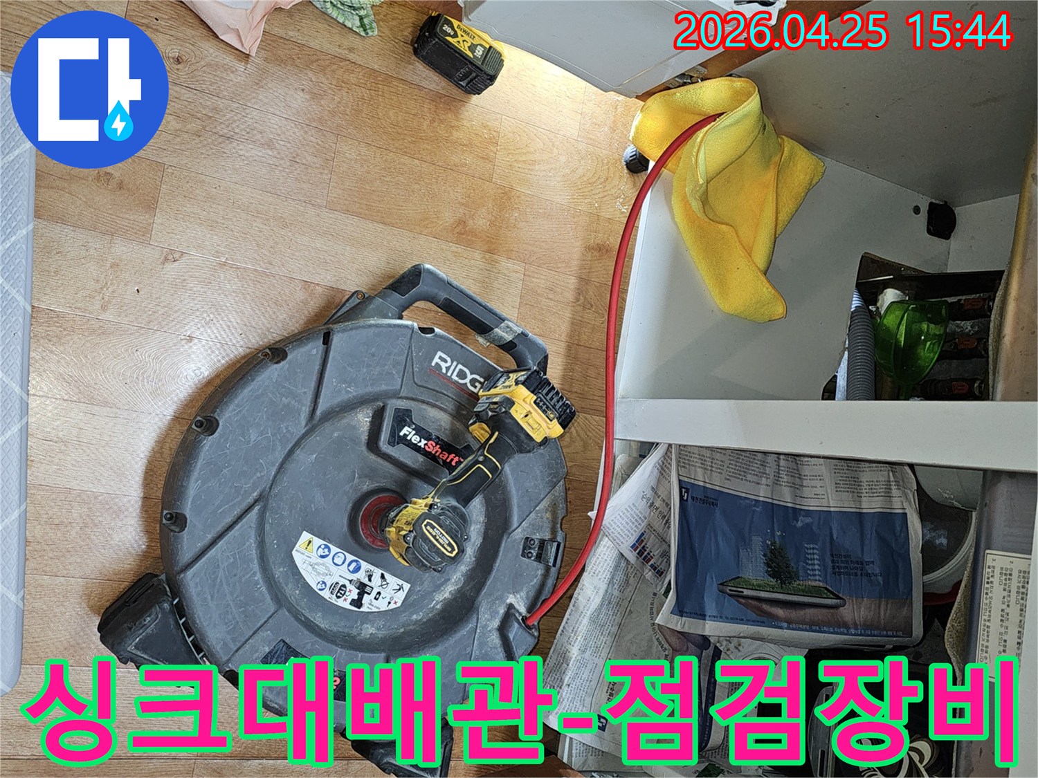 싱크대 하부 배관의-누수 원인을 파악하고-배관 막힘을 제거하기 위해-전문 장비를 준비하는 모습