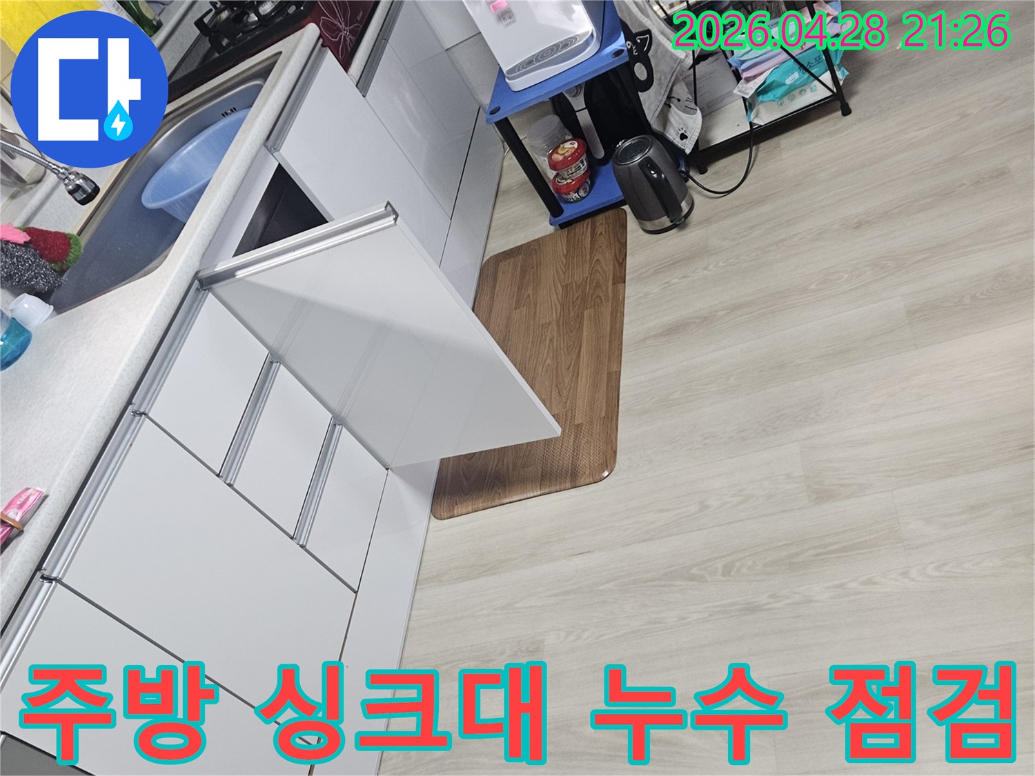 주방 싱크대 주변에서 발생한 누수를-정밀하게 탐지하기 위한-준비 작업을 보여주는 이미지입니다.