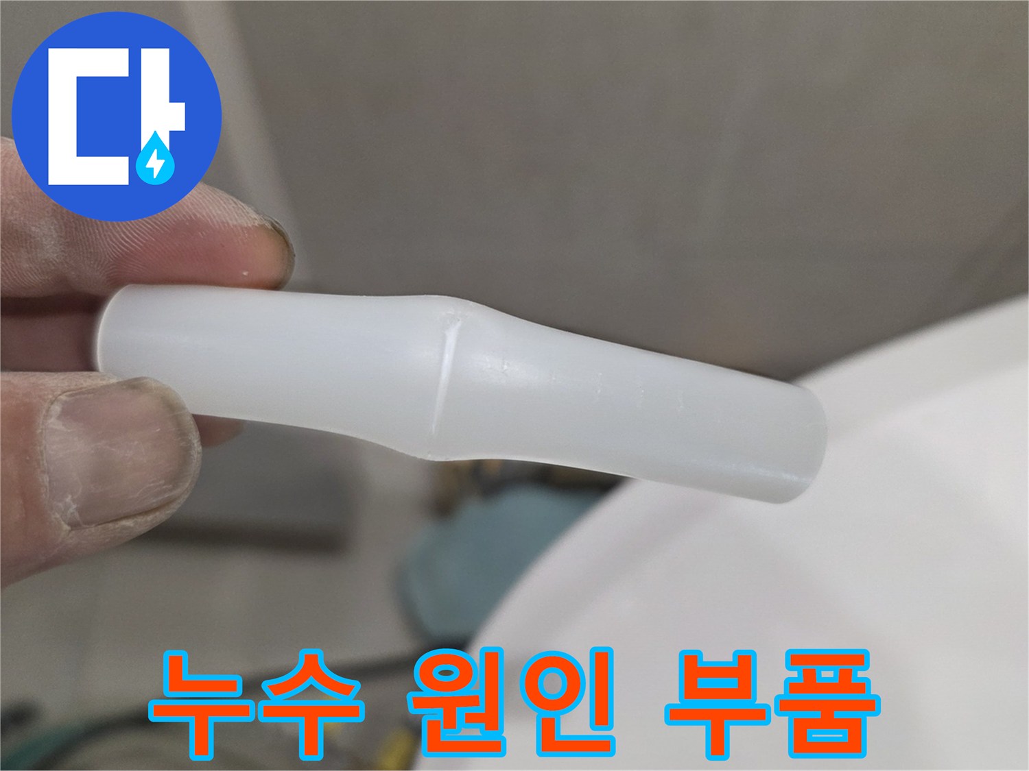 손에 쥐고 있는 파손된 하얀색 플라스틱 배관 연결재