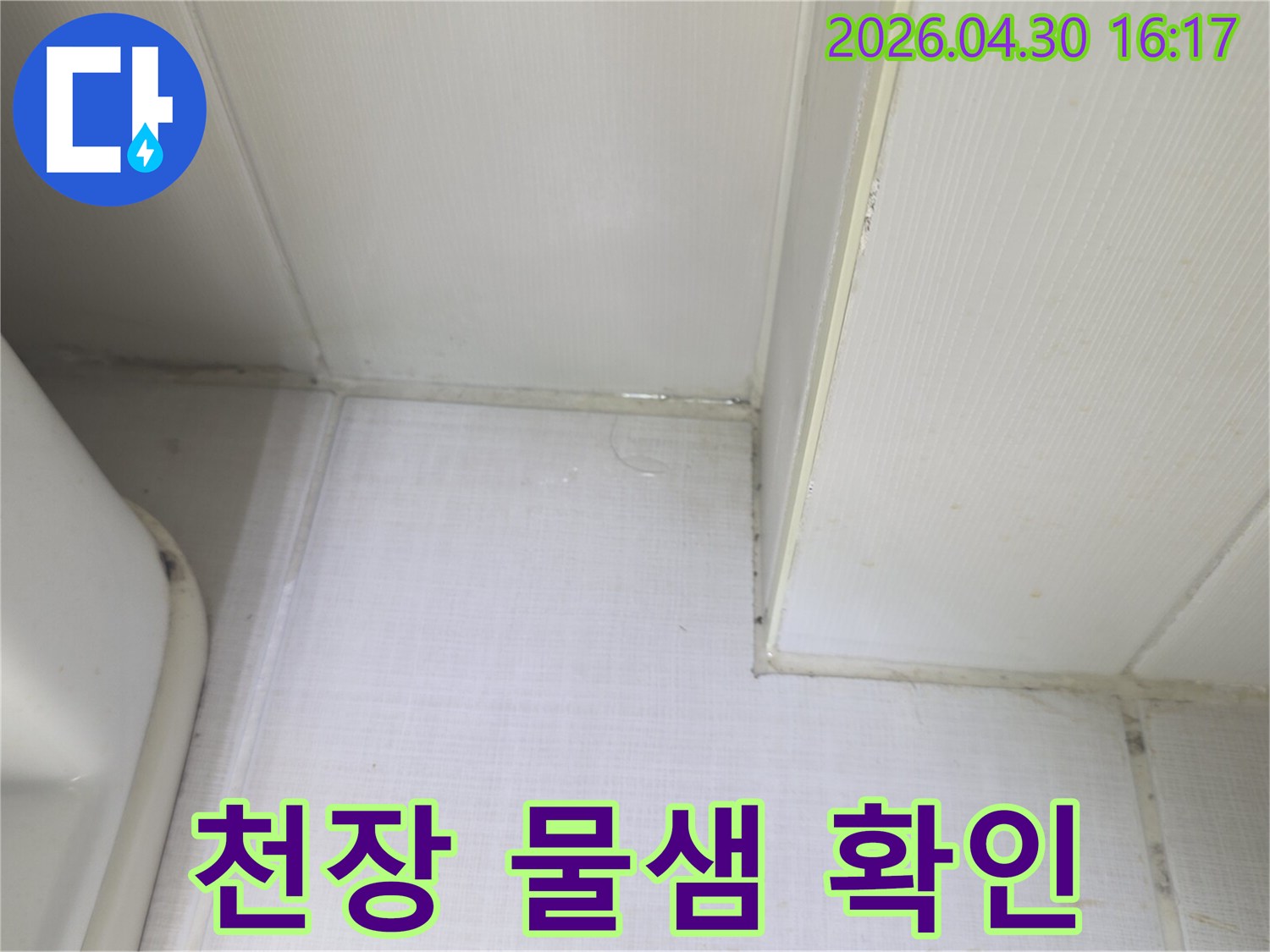 천장과 벽의 접합부에서 물이 새어 나와-벽지가 젖어있는 상태를 보여주는-누수 발생 현장의 증거 사진