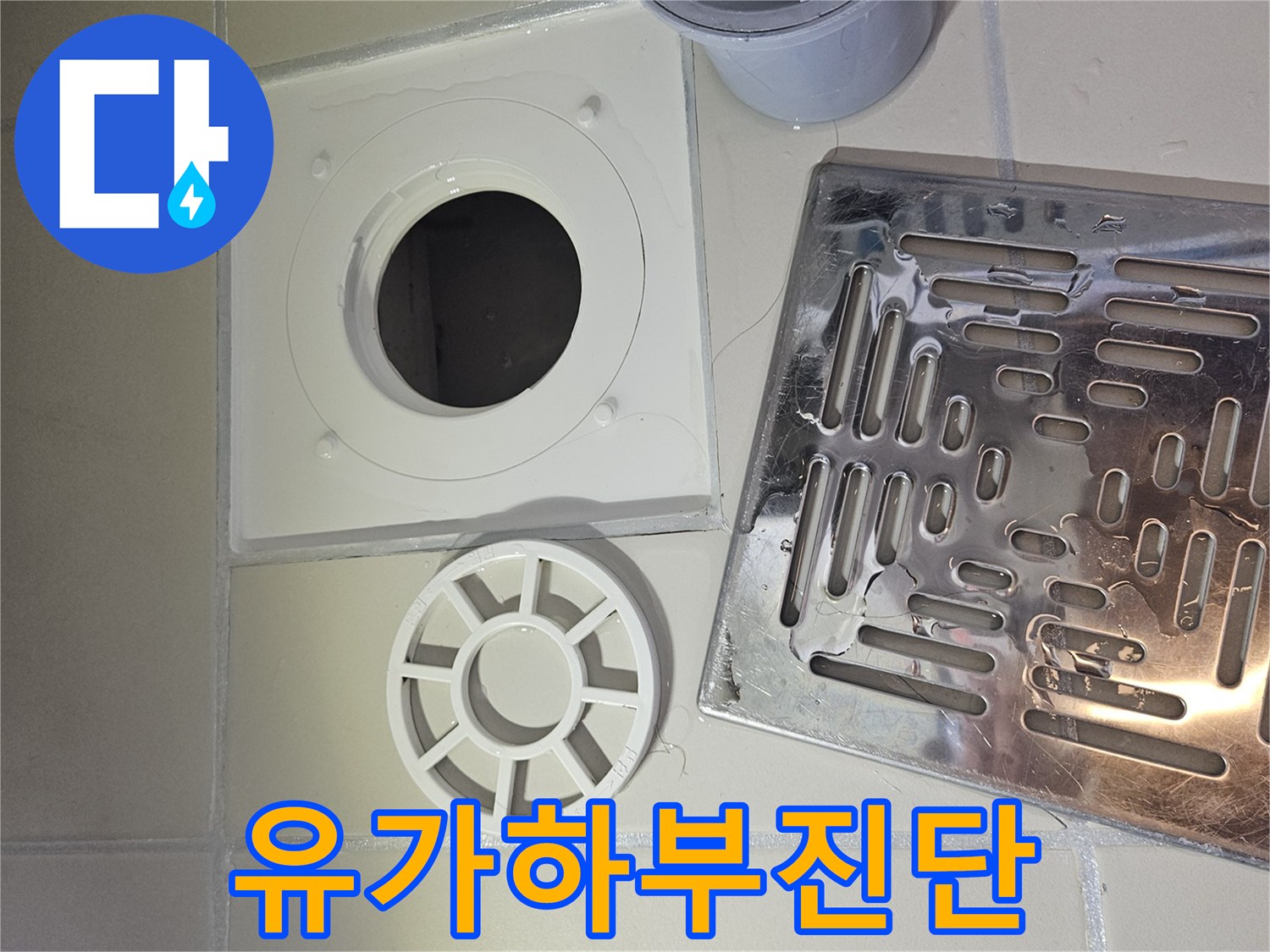 누수 원인을 찾기 위해 욕실 배수구-유가 하부 구조를 면밀히 검토하는 전문가의 모습