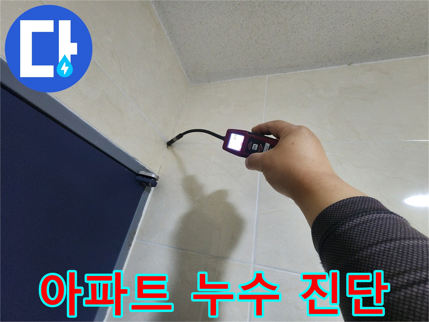 누수 전문 엔지니어가-아파트 내부의 타일 벽면에서-첨단 장비로-누수 여부를 꼼꼼하게 진단하고 있습니다.