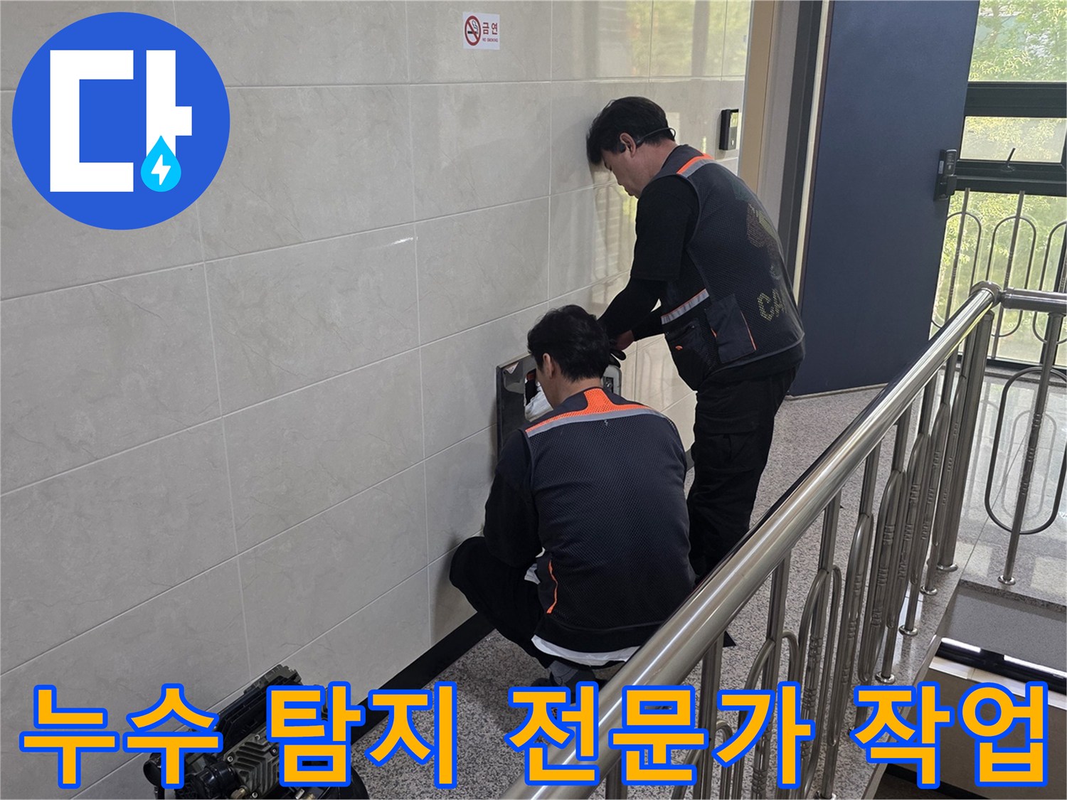 두 명의 숙련된 엔지니어가 건물 벽면의 누수 의심 지점을 정밀하게 탐지하고 있습니다-믿을 수 있는 전문가의 정확한 진단 과정입니다.