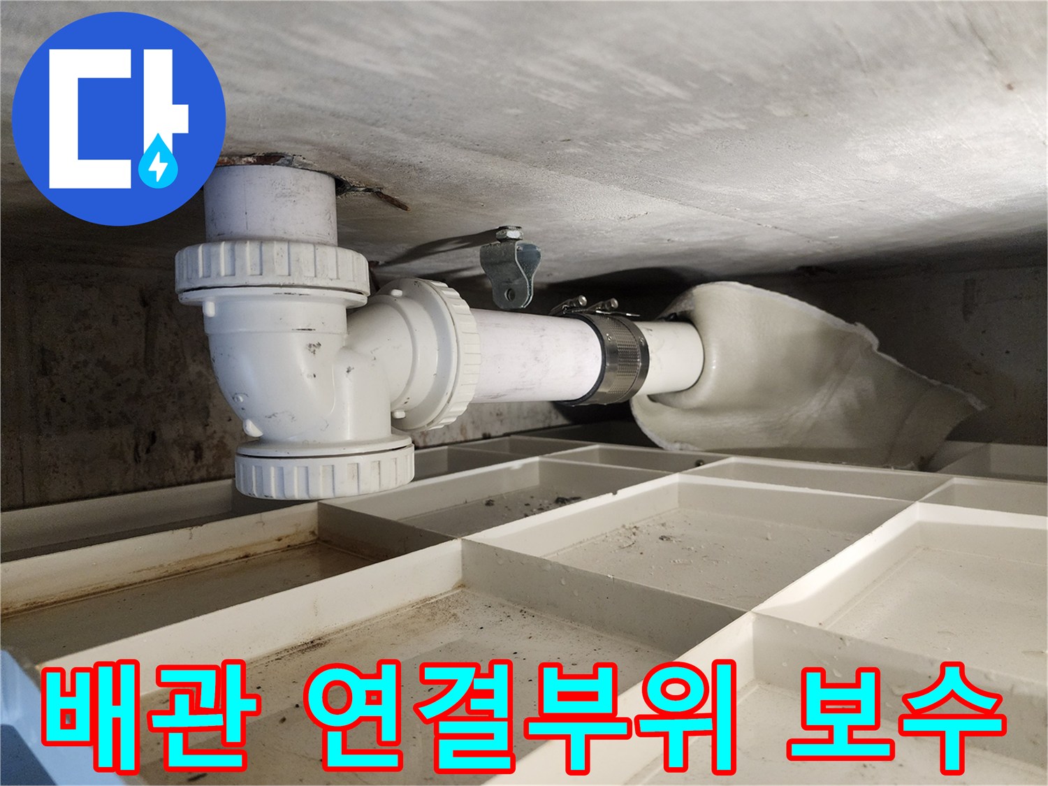 천장 아래 배관의-연결 부위가-새로운 부품으로-견고하게 보수된 모습입니다