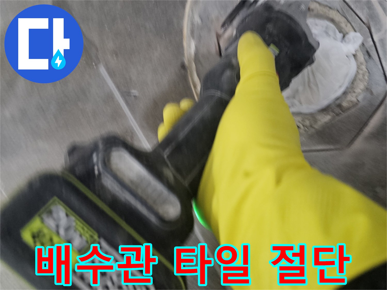 노란색 보호 장갑을 착용한-작업자가-전동 공구를 이용해-배수관 주변의-굳은 타일을-조심스럽게 절단하는 모습입니다.