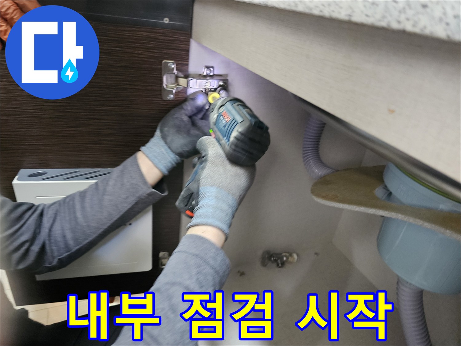 누수 엔지니어가-싱크대 누수-내부 점검을-시작하기 위해-하부장 패널을-분리하는-장면