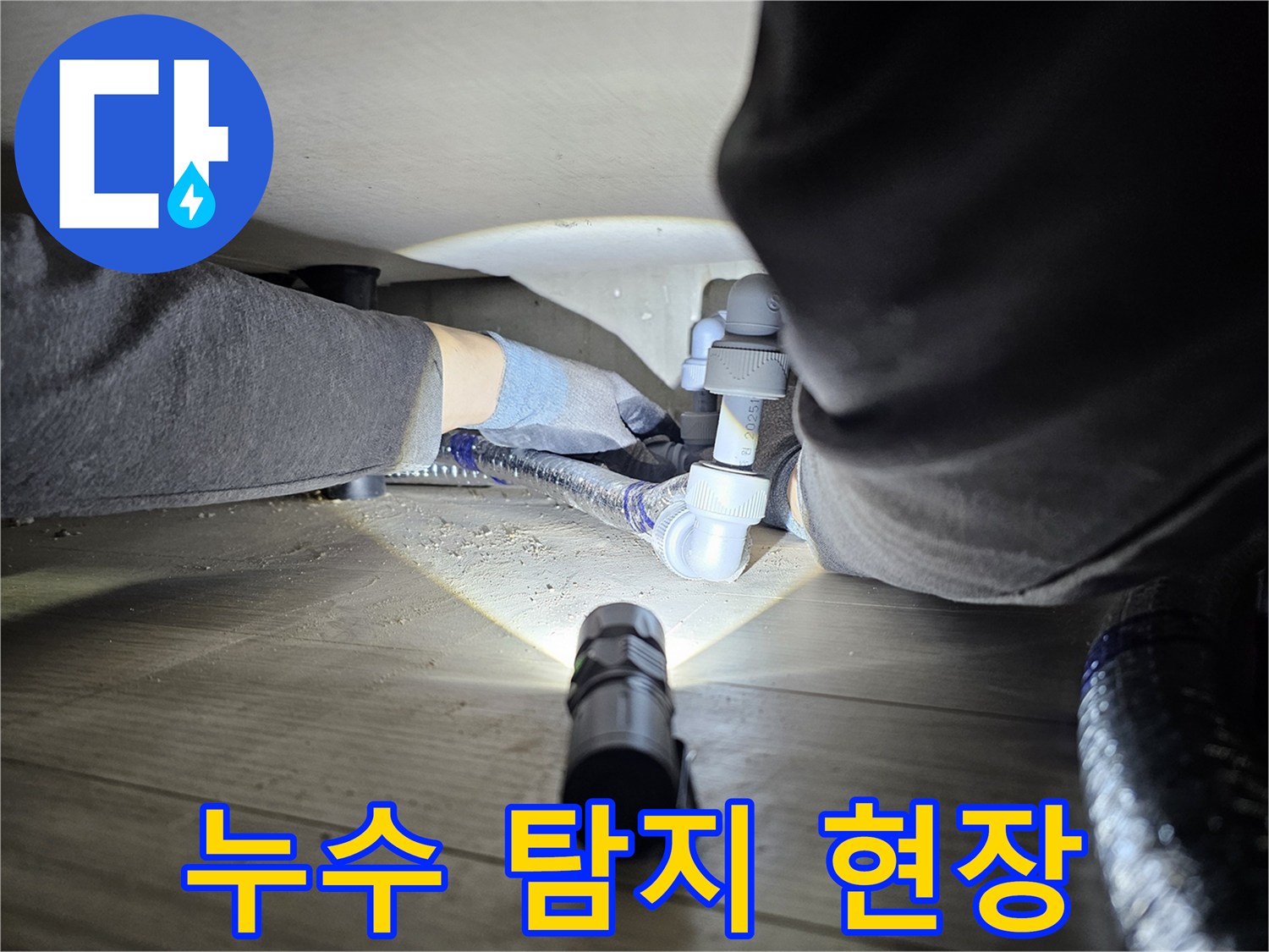 누수-탐지-전문가가-어두운-공간에서-배관-연결부를-확인하는-모습